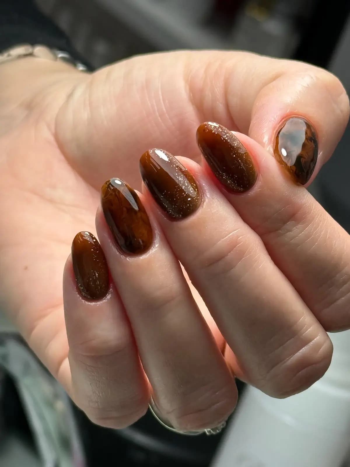 Almond nails in copper brown with a cat-eye flash