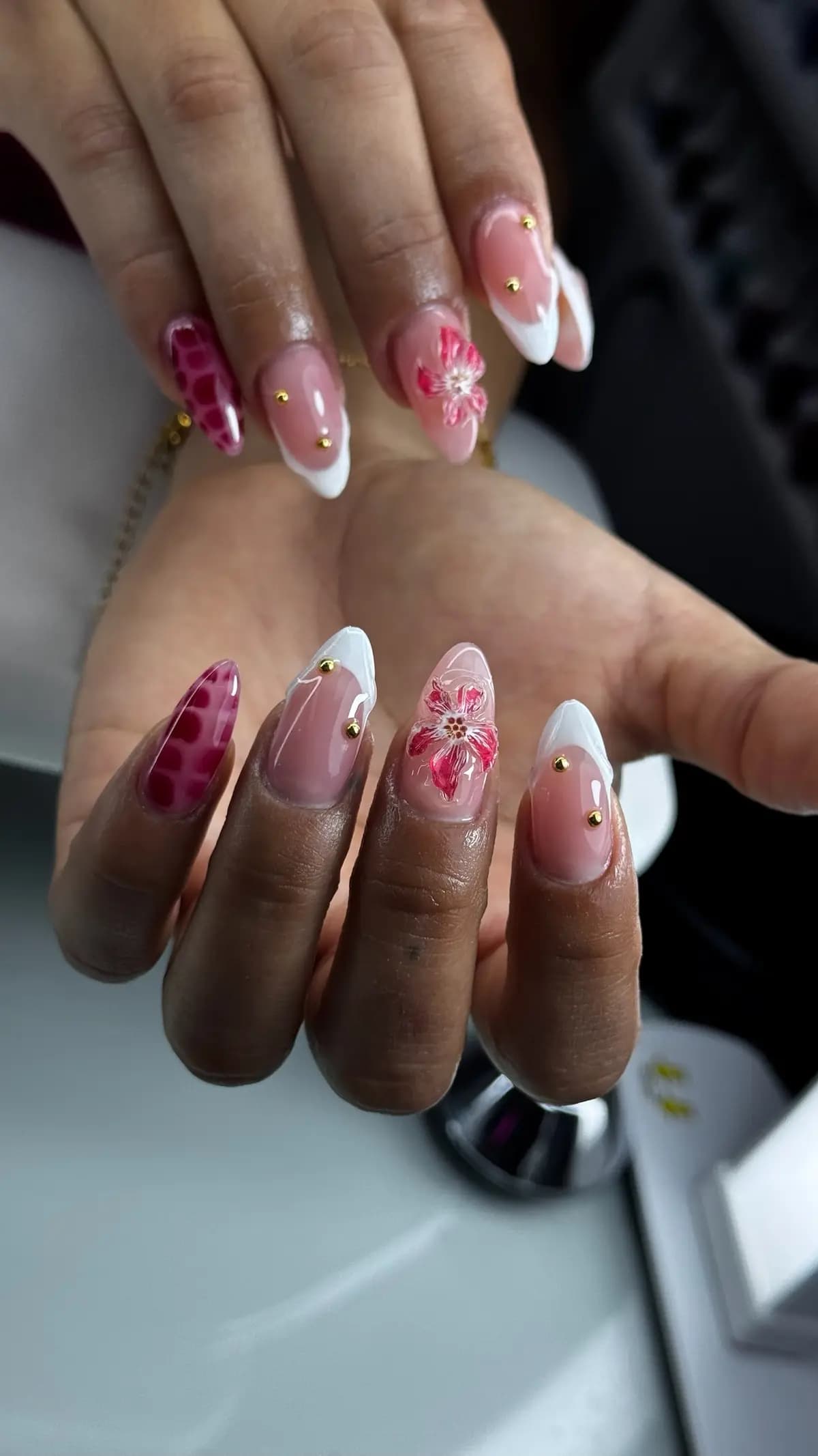 Nails with hand-painted pink and red flowers over a nude base