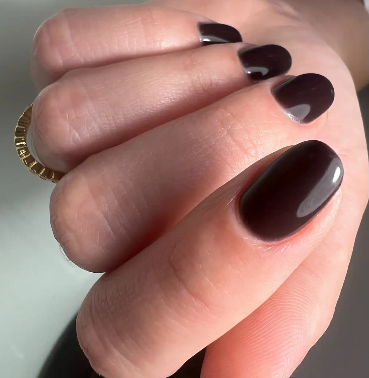 Short rounded nails in dark burgundy gel with a mirror finish