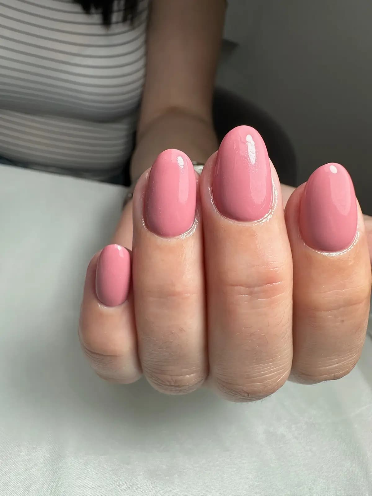 Bubblegum pink gel manicure on short round nails, tidy cuticles