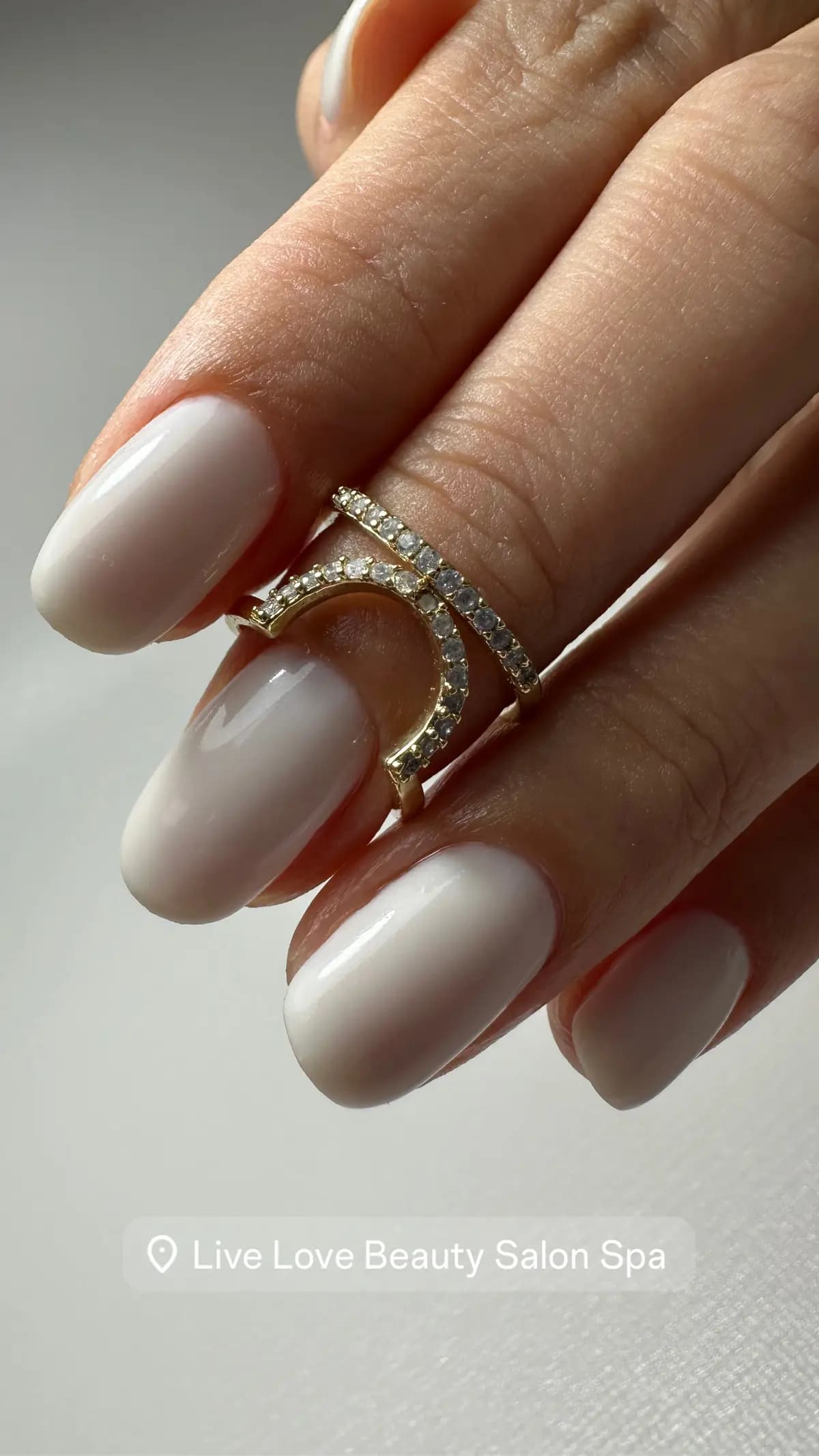 Almond nails in milky white gel paired with pavé rings