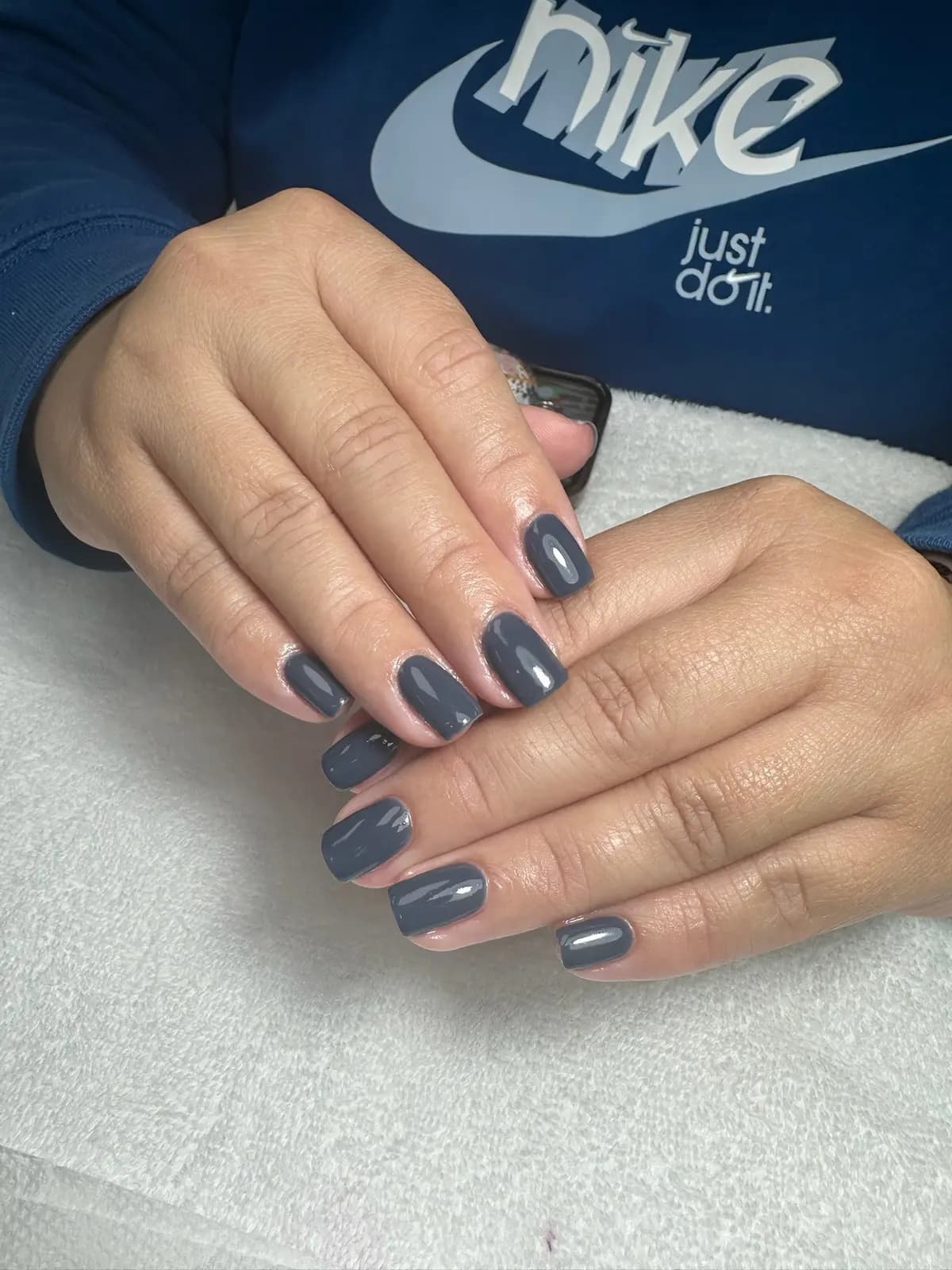 Slate grey gel manicure on short nails, both hands resting