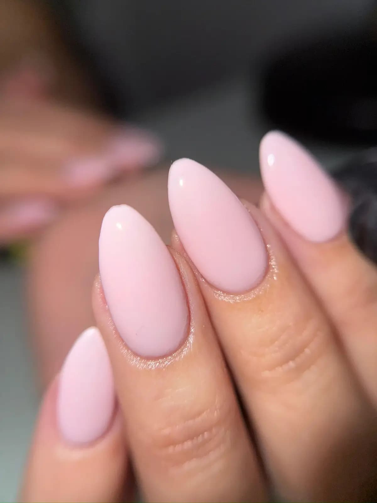 Close up of baby pink gel almond nails with high gloss