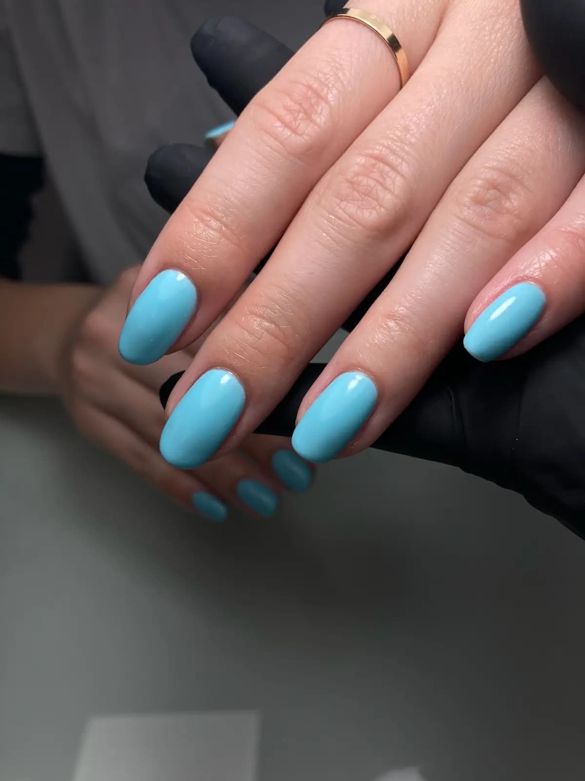 Turquoise gel manicure on rounded nails, both hands