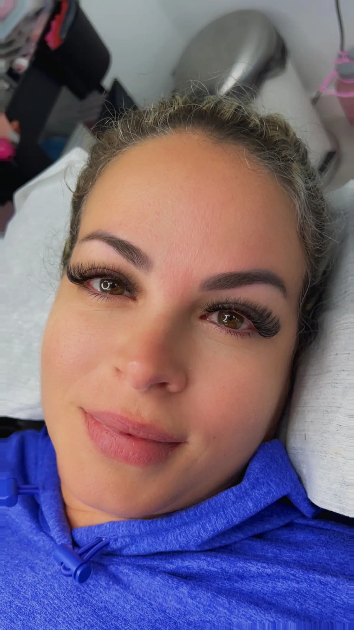 Client with worked brows and new lashes, portrait on the bed