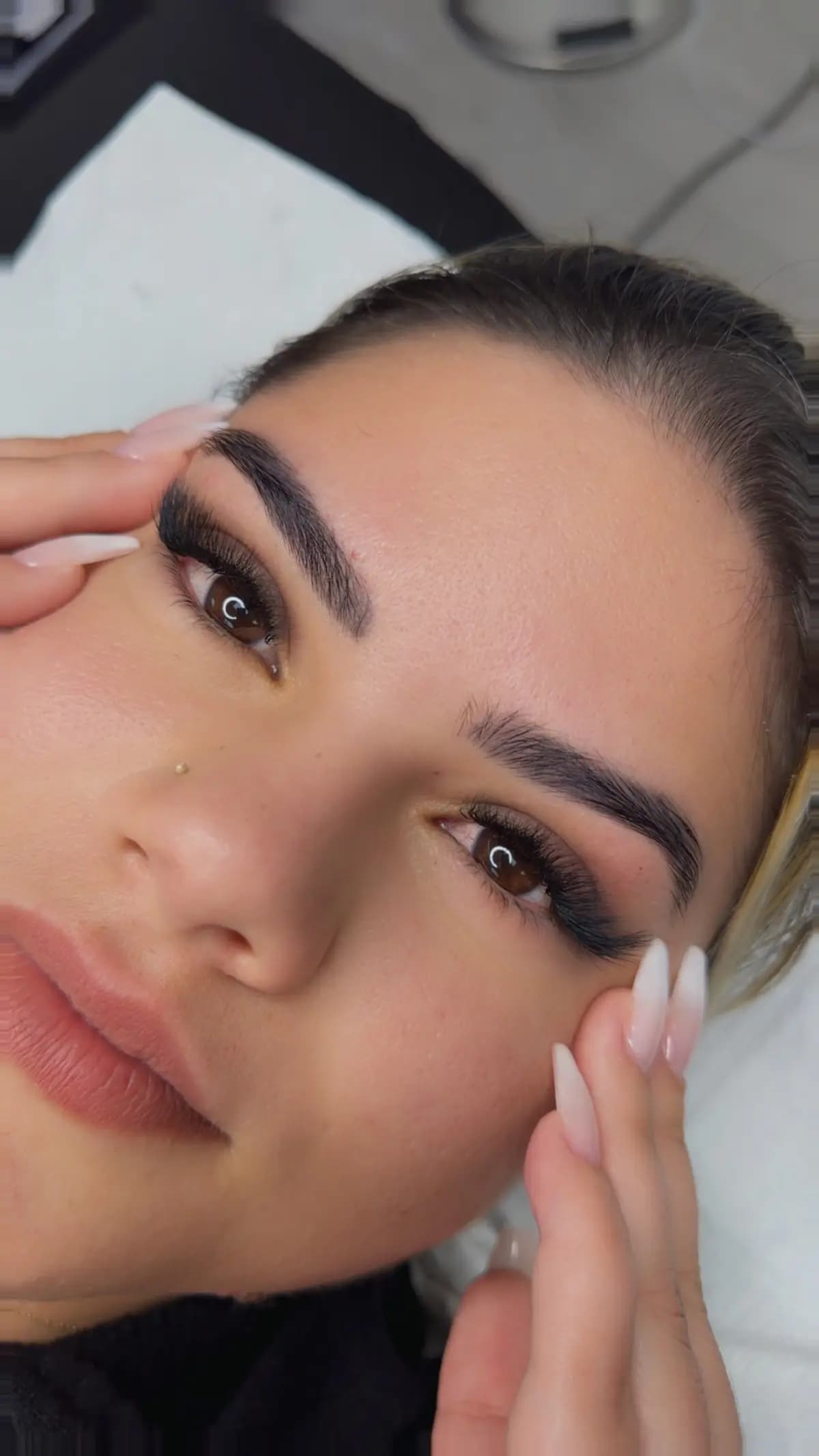 Checking the brow shape during the appointment