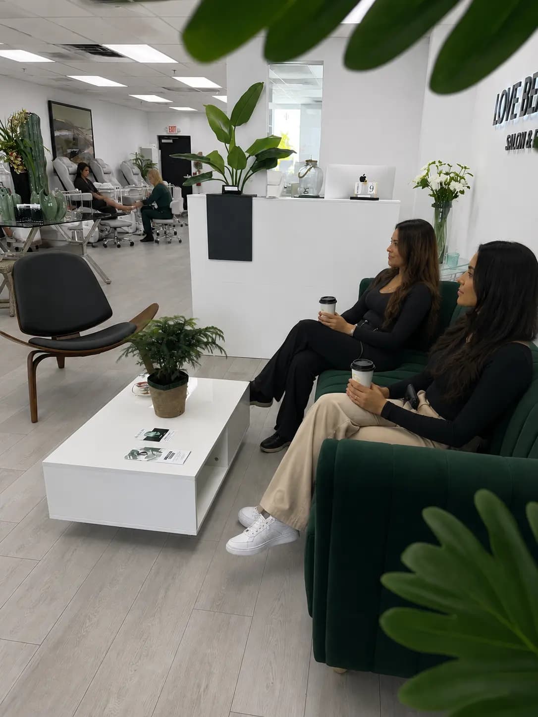 Waiting area with the green sofa, plants and clients seated