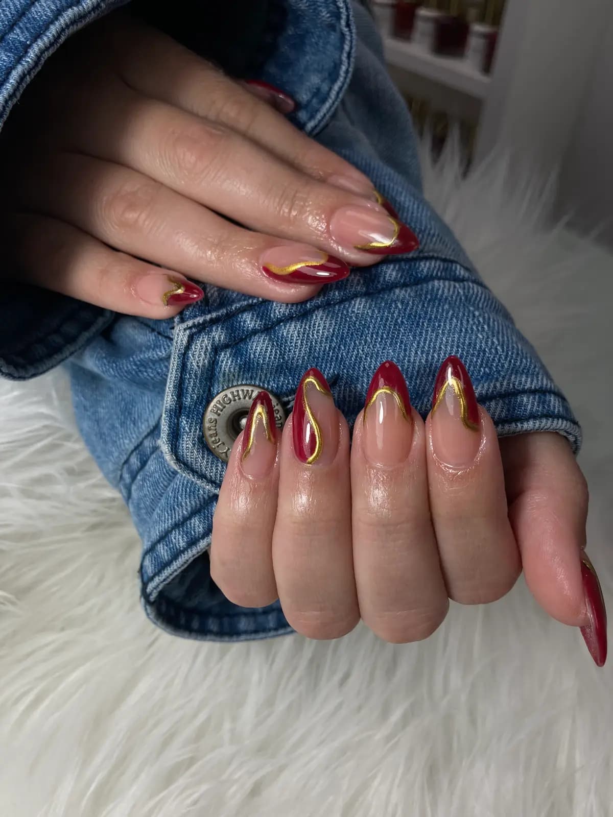 Red and nude stiletto nails with gold chrome tips