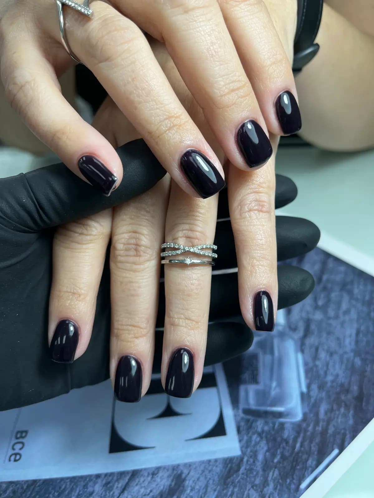 Black gel almond nails with high gloss and silver rings