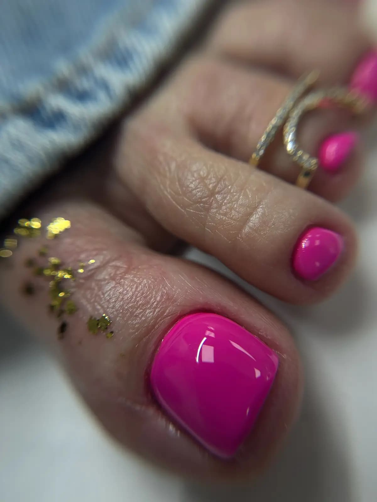 Toenails in fuchsia with gold foil and toe rings
