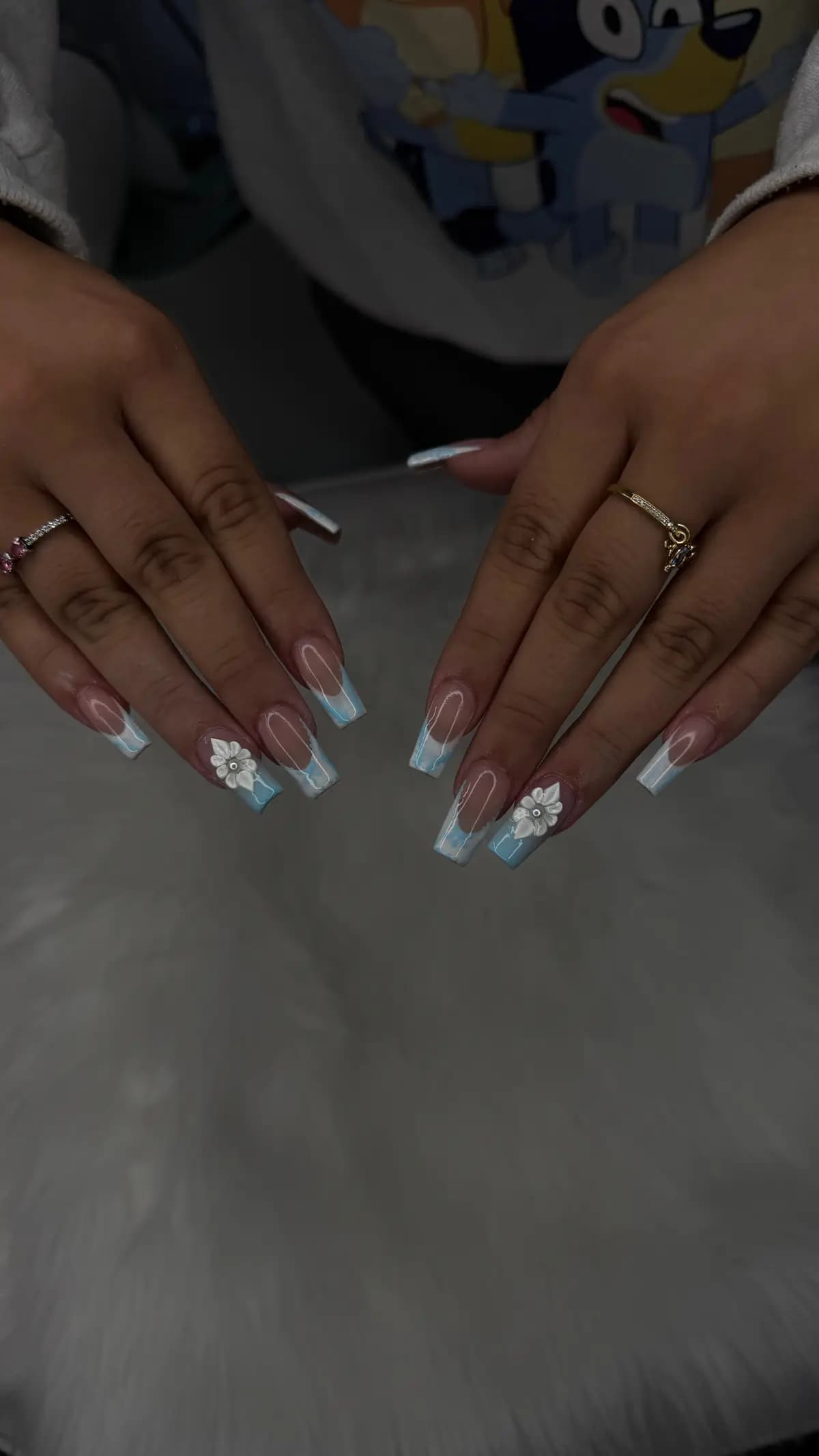 Long nails with blue french and raised white flowers