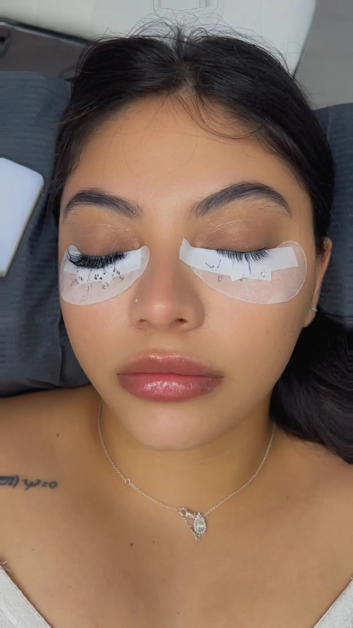 Extensions being applied with pads under both eyes