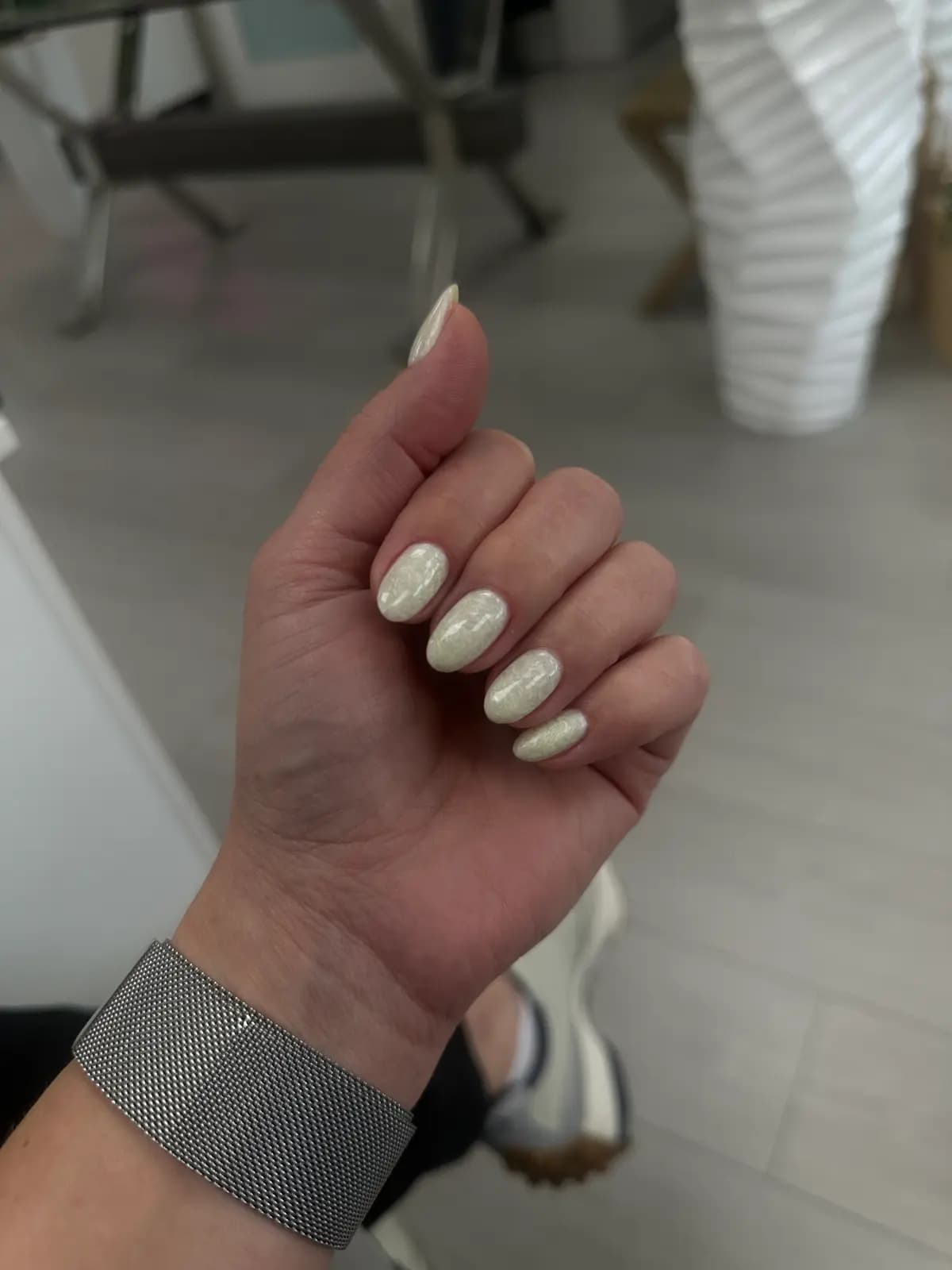 Pearlescent white gel manicure on almond nails, closed hand