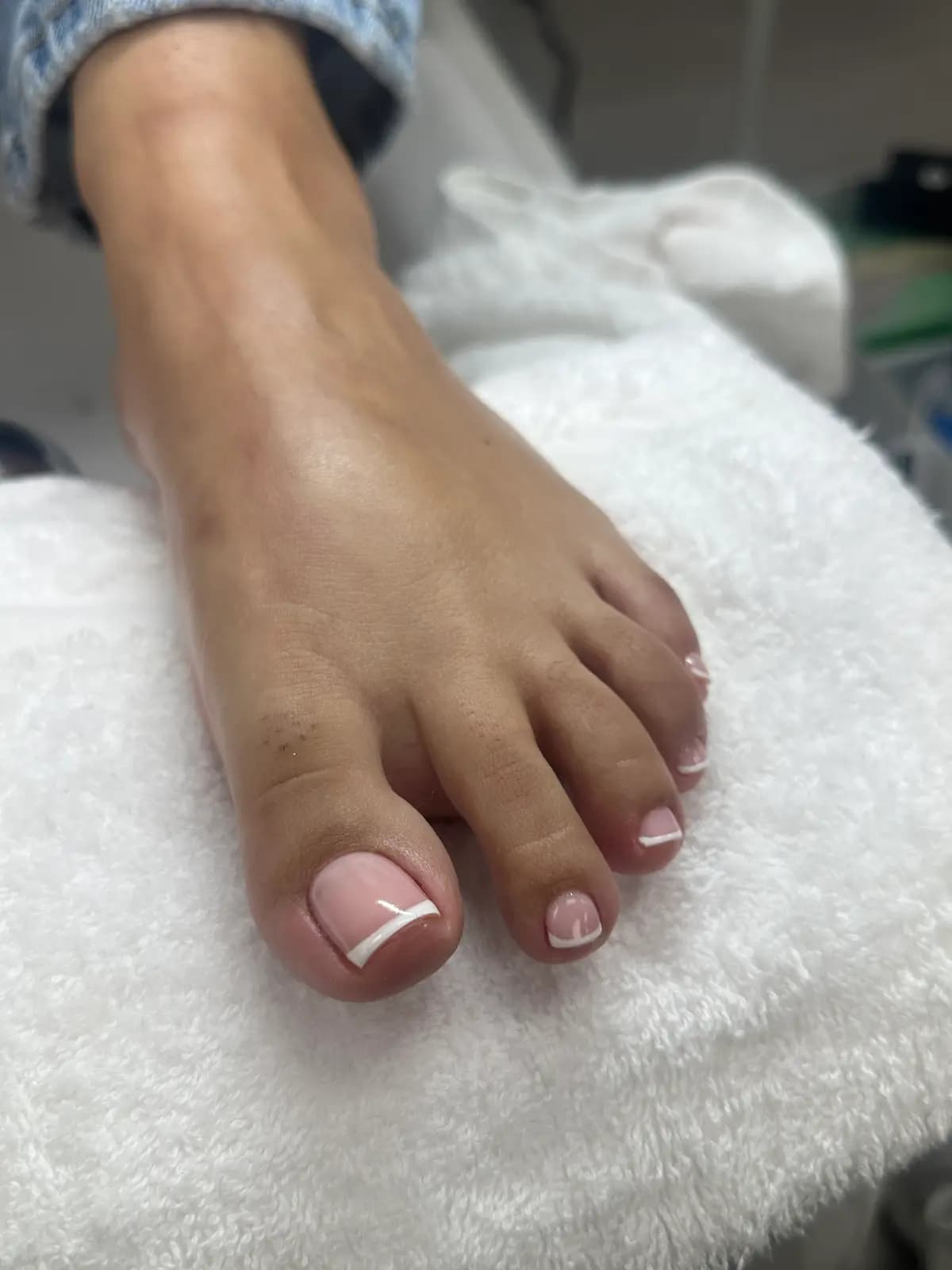 White french on toes, on the pedicure station towel