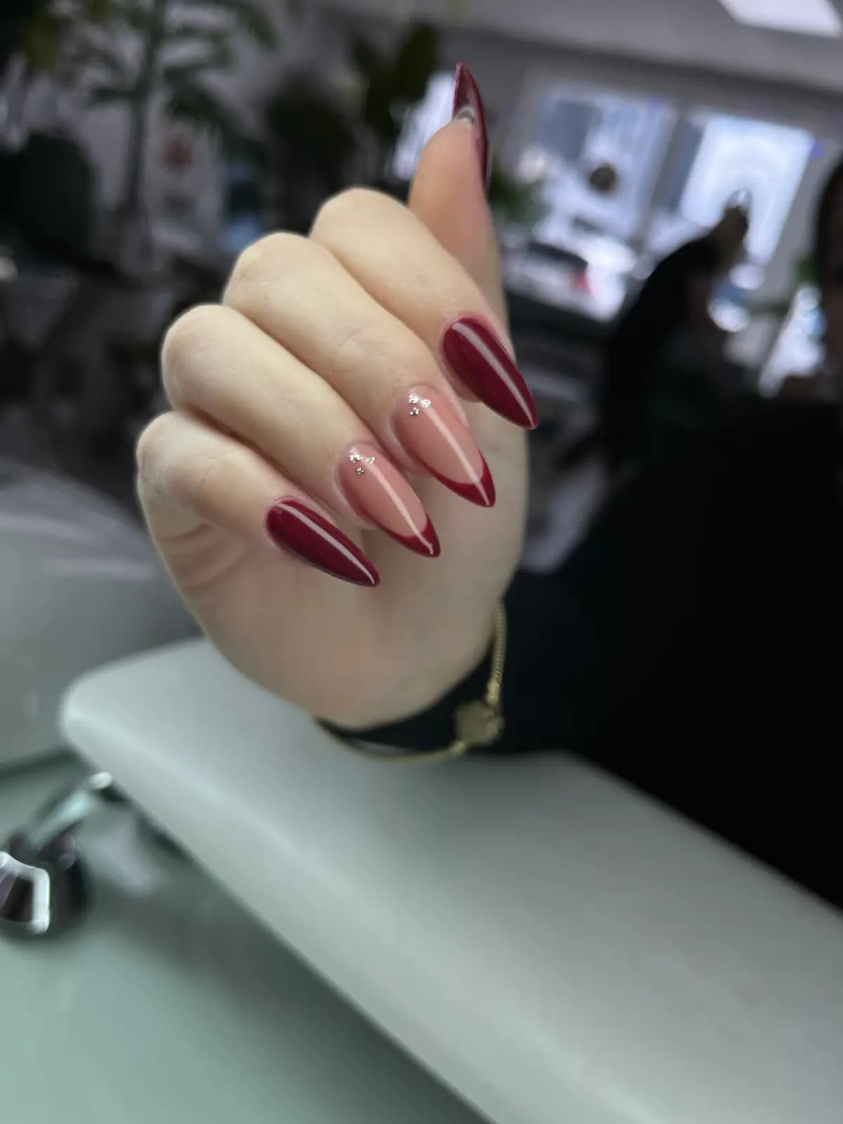 Long stiletto nails in dark red, closed hand