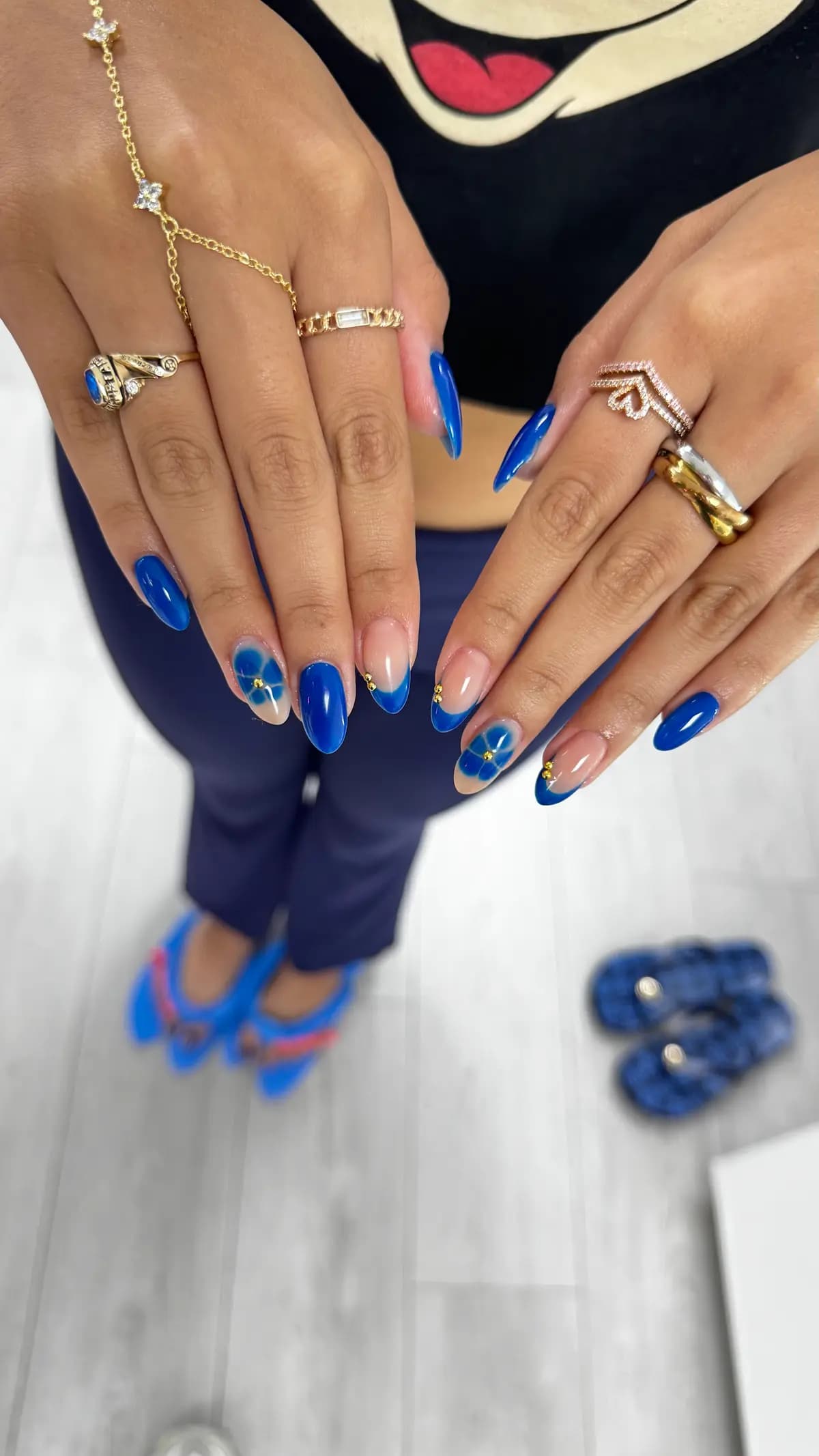 Klein blue nails with painted white flowers and gold rings