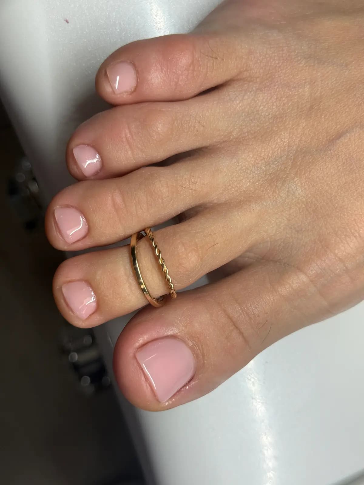 Natural nude pedicure with worked skin and a toe ring, close up