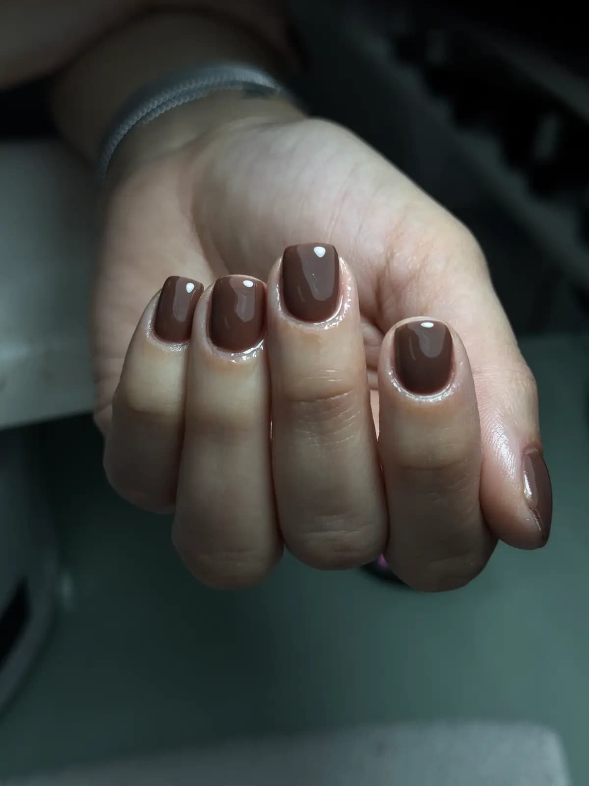 Short nails in chocolate brown gel, closed hand